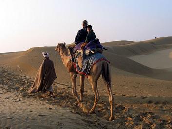 Benegal Dinker riding a camel on the sand dunes at Sam-Dhani, 40 km from Jaisalmer, with a five-year-old guide at the back. December 2007. © Arvind Benegal 2007