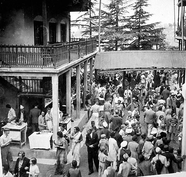 The Woodstock Sale. Mr. Parker, the Principal in the dark suit (left foreground, appears in the midst of the hustle and bustle in the central Quadrangle. (1936?) Woodstock school sale day